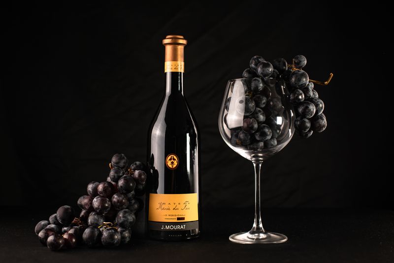 Boca crnog vina Plavac Mali na drvenom stolu